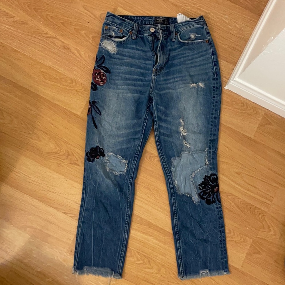 Ripped jeans with flower patches.